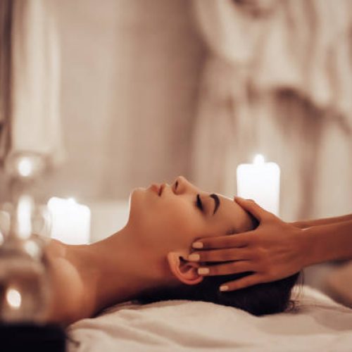 istockphoto-941310350-612×612 Attractive young woman is relaxing in spa and wellness center while receiving head massage. Beauty treatment concept.